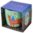 Aufschrift: „Frida Kahlo“. Illustration einer Tasse mit einem Reh und zwei Vögeln, verpackt in dekorativer Box.