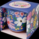 "Bunte Blumengrüße", "Kaffeebecher". Ein bunter Becher in einer blumig verzierten Verpackung mit floralen Motiven.