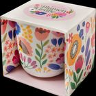 "Bunte Blumengrüße" und "Kaffeebecher". Bunter Becher mit Blumendesign in einer passenden Geschenkbox.