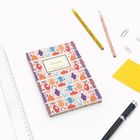 "NOTIZBUCH", "INSEL-BÜCHEREI" auf einem bunt gemusterten Notizbuch. Daneben Lineal, Stifte, Büroklammern.