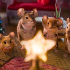 "9V" auf einer Batterie. Vier Mäuse stehen um einen leuchtenden Stern. Im Hintergrund ein Weihnachtsbaum und Möbel.