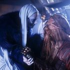 Szene mit zwei futuristischen Kreaturen, eine mit blauer Haut in einem blauen Mantel, die andere mit braunem Bart und Rüstung.