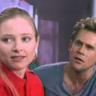 Ich kann keine spezifischen Texte im Bild erkennen. Es zeigt eine Frau in Rot und einen Mann, sie schauen in verschiedene Richtungen.