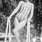 "FBI Agent Eddie wieder Colt-richtig." Eine Frau in einem gestreiften Badeanzug lehnt an einem Gartenstuhl.