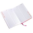 Text „HAPPY BIRTHDAY“ und Monatsnamen. Geöffnetes Notizbuch mit Kalenderaufteilung, rosa Band als Lesezeichen.