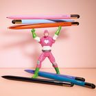 Die Stifte tragen den Aufdruck "CEDON". Figur in rosa Superheldenkostüm hält bunte Stifte hoch. Hintergrund ist rosa.
