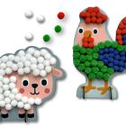 Illustration eines Schafes und Hahns aus bunten Pompons. Schaf mit weißen, Hahn mit roten, grünen und blauen Pompons.