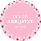 HEUTE. HIER. JETZT. LEO TOLSTOI. Rosa Hintergrund mit Blumenrand.