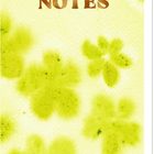 "NOTES" steht auf einem pastellgelben Hintergrund, verziert mit grünen Blumenmustern. Oben ist eine Spiralbindung.