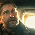 Ein Mann mit Bart und schmutzigem Gesicht in einem Transportmittel, das Licht scheint durch ein Fenster.