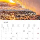 Kalendarium: Januar 2027. Foto: Sonnenuntergang hinter einem großen Eisblock am Kiesstrand.