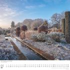 „Winter“ in den Broughton Grange Gardens, Oxfordshire. Frostiger Garten mit geschnittenen Hecken und klarem Himmel.