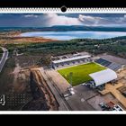 "11FREUNDE" oben rechts, großer Kalender mit Nummer 4 unten links, Stadion in Landschaft mit See im Hintergrund.