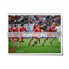 "Vorjahresabbildung". Kalenderseite zeigt jubelnde Fußballspieler in roten Trikots auf einem Spielfeld.