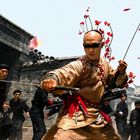 Kämpfer in traditioneller Kleidung mit Schwertern, umgeben von Kriegern, rote Blütenblätter schweben in der Luft.
