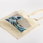 Eine beigefarbene Stofftasche mit Hokusais bekanntem Kunstwerk "Die große Welle vor Kanagawa".