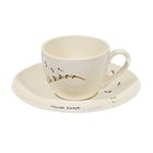 „Musik lässt“ steht auf einer weißen Tasse mit Notenlinien, begleitet von einer passenden Untertasse.
