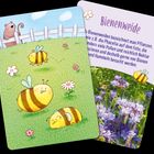 "Bienenweide" Text über Pflanzen mit Pollen. Illustration mit Bienen auf grünem Feld und Blumen, Zaun und Bär im Hintergrund.