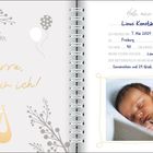 Links: "Hurra, hier bin ich!" in gelber Schrift. Rechts: Babyfoto, daneben ein Geburtsdaten-Tagebuch.