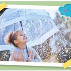 Ein Kind lächelt unter einem transparenten Regenschirm. Oben rechts eine niedliche, lachende Regenwolke.