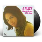 „A TASTE Ricardo Marrero & The Group“ in pinker Schrift. Porträt einer Frau mit schulterlangem Haar. Vinyl-Rand sichtbar.