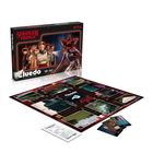 Auf der Verpackung steht „Stranger Things“ und „Cluedo“. Ein Spielbrett mit Karten und einem Monster ist abgebildet.