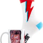 Eine Tasse mit einem Porträt, roter Blitz auf weißer Socke mit rotem Bund und blauem Saum.