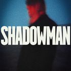 Text: "SHADOWMAN". Unscharfe Figur, vorwiegend blau-rot gehalten, verschwommen.