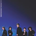 Links vertikaler Text: "BRIGITTE CALLS ME BABY / IRREVERSIBLE". Fünf Personen in schwarzer Kleidung vor blauem Hintergrund.