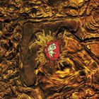 Keine erkennbaren Texte. Ein abstraktes Gemälde mit goldenen, fließenden Formen und einer roten Figur in der Mitte.