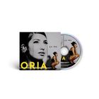 Text: "ÇA IRA", "ORIA". Eine Frau sitzt in Schwarz-Weiß, nachdenklich in Nahaufnahme abgebildet. 