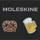Oben steht in weißem Text "MOLESKINE". Darunter sind eine Brezel und ein Bierkrug als Emoticons zu sehen.