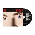 "DE STAAT" in Rot, darunter Songtitel in Weiß auf Schwarz. Nahaufnahme von Augen, teils von einer CD verdeckt.