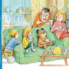 Links: "At Home", gefolgt von einem kurzen Text über Paddington. Rechts: Illustration einer Familie auf einem Sofa mit Tee.