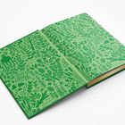 Keine Texte. Eine Illustration mit grünen Pflanzenmotiven und einem Vogel, eingedruckt auf einem aufgeklappten Buch.