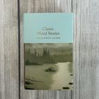 "Classic Weird Stories, Edited by Emily Alder." Ein Buch mit einem Landschaftsbild von einem See und Bäumen.