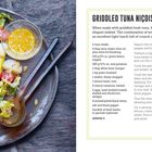 "GRIDDLED TUNA NIÇOISE," Rezepttext neben einem Teller mit Salat, Ei, Tomaten, Thunfisch und Dressing in einer Schale.