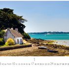 "Morbihan" steht unten links. Ein idyllisches Steinhaus am Ufer mit Bäumen, Boote, und blauem Wasser im Hintergrund.