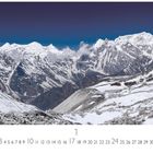 Annapurna. Gezeigt wird eine schneebedeckte Bergkette unter klarem, tiefblauem Himmel. Unten ein Kalender mit Zahlen.