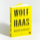 "Wolf Haas Wackelkontakt Roman." Gelbes Buchcover mit verschwommenem Schriftzug und einem kleinen Logo unten rechts.