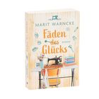 „Fäden des Glücks“ von Marit Warncke. Nähmaschine, Stoff, Blumen in hellem Raum.