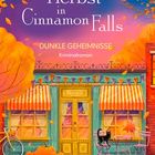 Herbst in Cinnamon Falls. Dunkle Geheimnisse. Kriminalroman. Illustrierte Straßenszene mit gelbem Gebäude, Katze und Kürbissen.