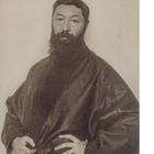 "HUCO ERFURTH DRESDEN." Porträt eines Mannes mit Vollbart, in einem dunklen Gewand, mit verschränkten Händen.