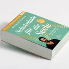 Titel: "Schokolade für die Seele". Ein Buch, türkisfarbenes Cover, mit einem Porträt und goldenen Punkten.
