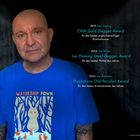 2019: CWA Gold Dagger Award. 2022: Ian Fleming Steel Dagger Award. 2023: Theakstone Old Peculier Award. Person im blauen T-Shirt.