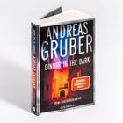 Buchcover für "Dinner in the Dark" von Andreas Gruber, "SPIEGEL Bestseller-Autor", lebhafte dunkle Straßenszene.