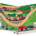 Illustration eines Zugbahnhofs mit Menschen und Fahrzeugen. Oben rechts Text über den Tagesbeginn in der kleinen Stadt.