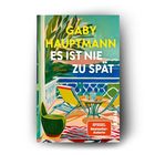 Buchtitel: "Es ist nie zu spät" von Gaby Hauptmann. Spiegel Bestseller. Illustration: Terrasse mit Stuhl, Tisch und Meerblick.
