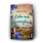 "HEIDI TROI: Liebe mit Alpenglück. Roman. Almwiese mit Holzhütten und Enzianblumen; Verlag Piper."