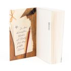„In der kleinsten Küche ist Platz für das größte Glück.“ Links Zettel mit Stift, rechts geöffnetes Buch.
